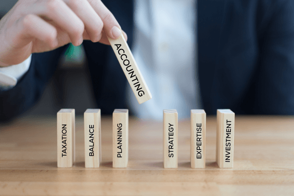Hand placing a wooden block labeled accounting alongside tax and strategy blocks for C P Agrawal And Associates CA Firm in Delhi